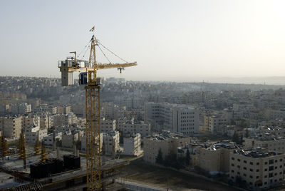 Crane in city against clear sky