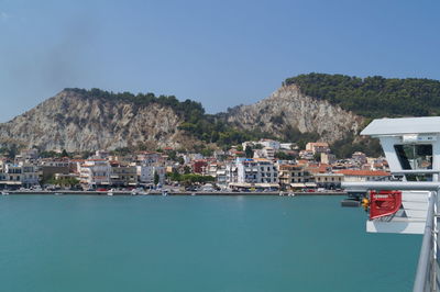 Sea by mountains against clear blue sky