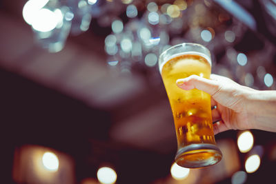 Close-up of hand holding beer glass