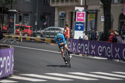 People riding bicycle on road in city