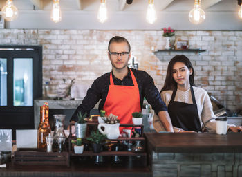 Portrait of owners standing in cafe