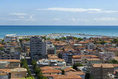 High angle view of townscape by sea against sky