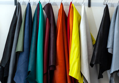 Close-up of multi colored clothes hanging on rack in store
