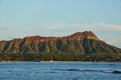 Scenic view of sea and mountains against sky