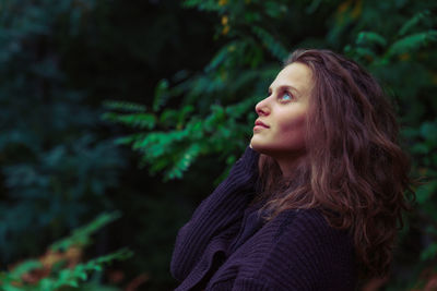 Beautiful young woman against trees