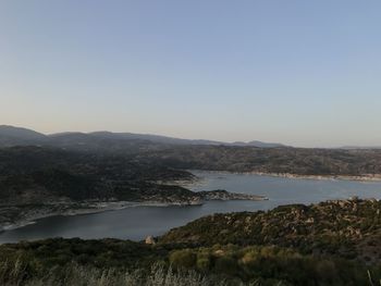 Scenic view of sea and mountains against clear sky