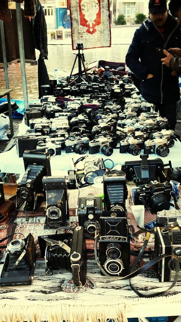 large group of objects, abundance, chair, arrangement, in a row, retail, stack, market, day, transportation, group of objects, variation, market stall, land vehicle, choice, for sale, order, street, incidental people, outdoors