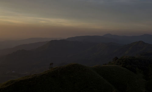 Scenic view of silhouette mountains against sky at sunset