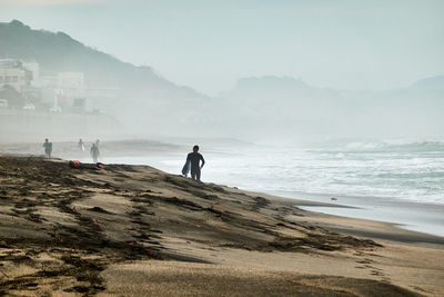 Man standing on beach against sky