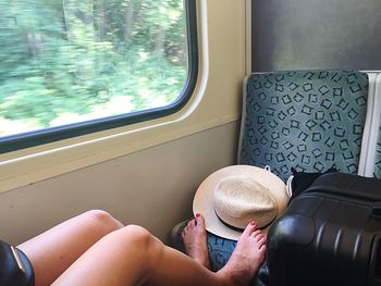 Low section of woman sitting in train