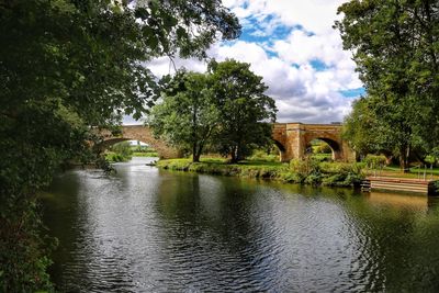 Arch bridge over river against sky