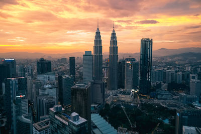 Aerial view of buildings in city during sunset