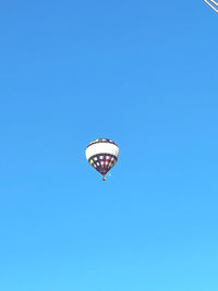 Low angle view of hot air balloon against clear blue sky