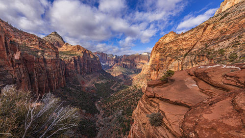 Panoramic view of rocky mountains against cloudy sky