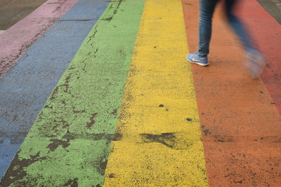 Low section of person walking on road
