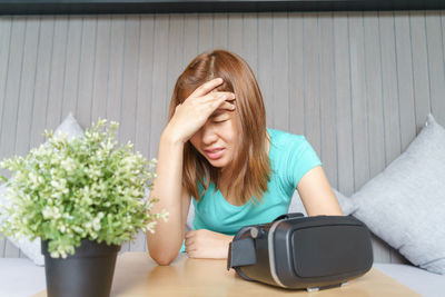 Woman with headache sitting at home
