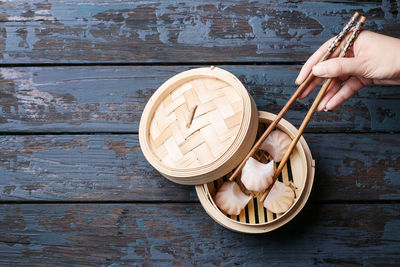 Cropped hand holding dumpling with chopsticks