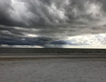 Scenic view of sea against storm clouds