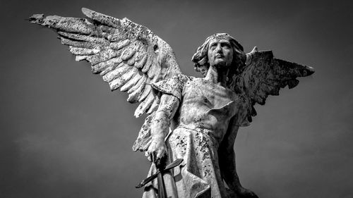 Low angle view of angel statue against sky