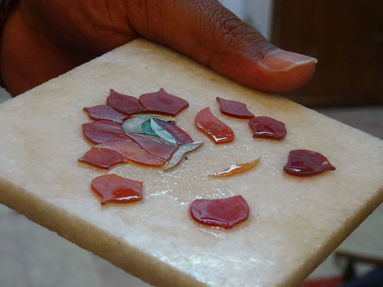 CLOSE-UP OF HAND HOLDING CAKE