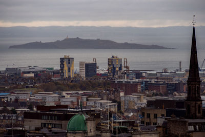 High angle view of city by sea against sky