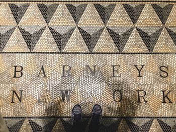Low section of man standing on tiled floor