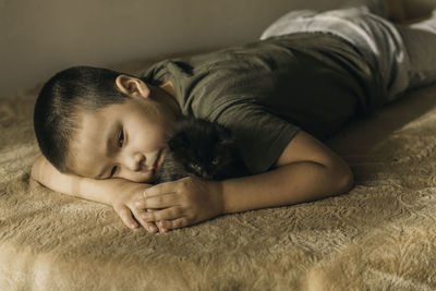 Portrait of an asian boy lying sad with a kitten