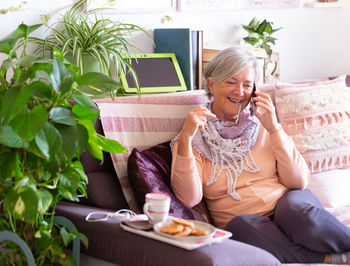 Midsection of woman using mobile phone while sitting outdoors