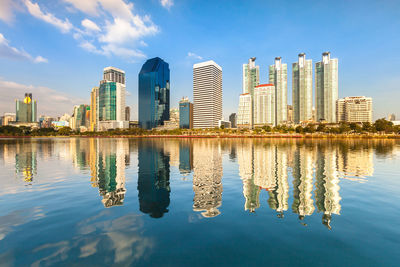 Reflection of modern buildings in city against sky