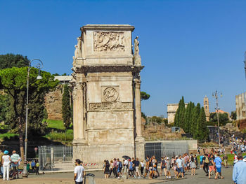 Group of people in front of building against blue sky