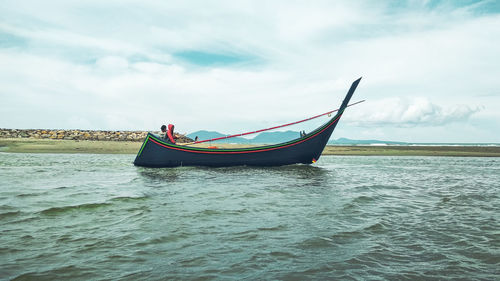 Boat moored on sea against sky