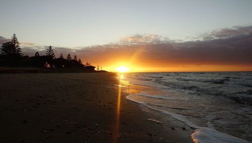 Scenic view of beach against sky during sunset