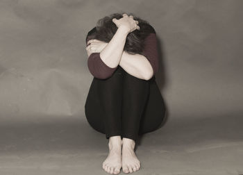 Midsection of woman standing against white background