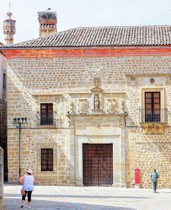 Rear view of people walking on street. edificio medieval. 