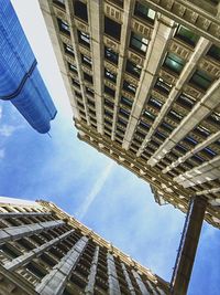 Low angle view of skyscrapers against blue sky