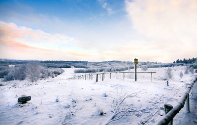 Scenic view of snow covered field against sky