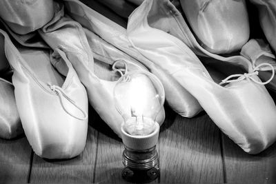 Ballet shoes on wooden floor glowing in light bulb