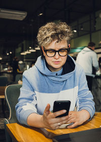 Woman using smart phone at cafe