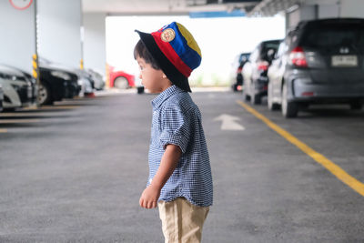 Full length of boy standing on road in city