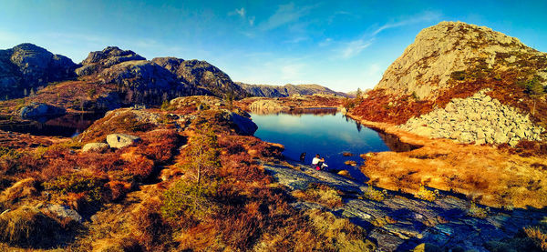 Scenic view of lake and mountains against blue sky