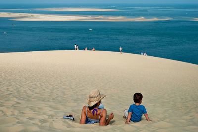 Rear view of people overlooking calm sea