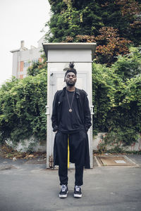 Portrait of man standing against trees