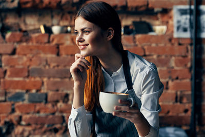 Portrait of young woman drinking coffee