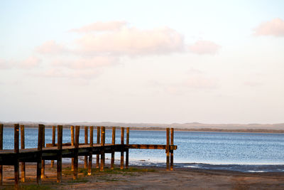 Pier on sea against sky during sunset