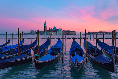 Boats moored in canal against sky