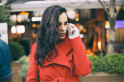 Young woman talking on mobile phone in city