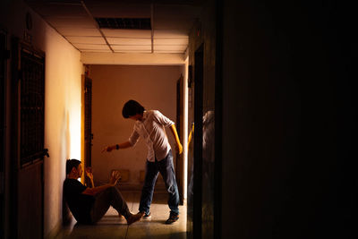 Side view of man standing at entrance of building