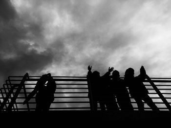 Silhouette people on staircase against sky