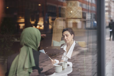 View through window of women in cafe