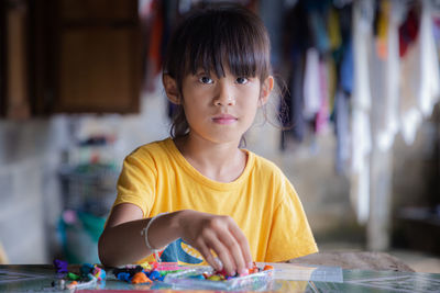 Portrait of cute girl playing with clay at home